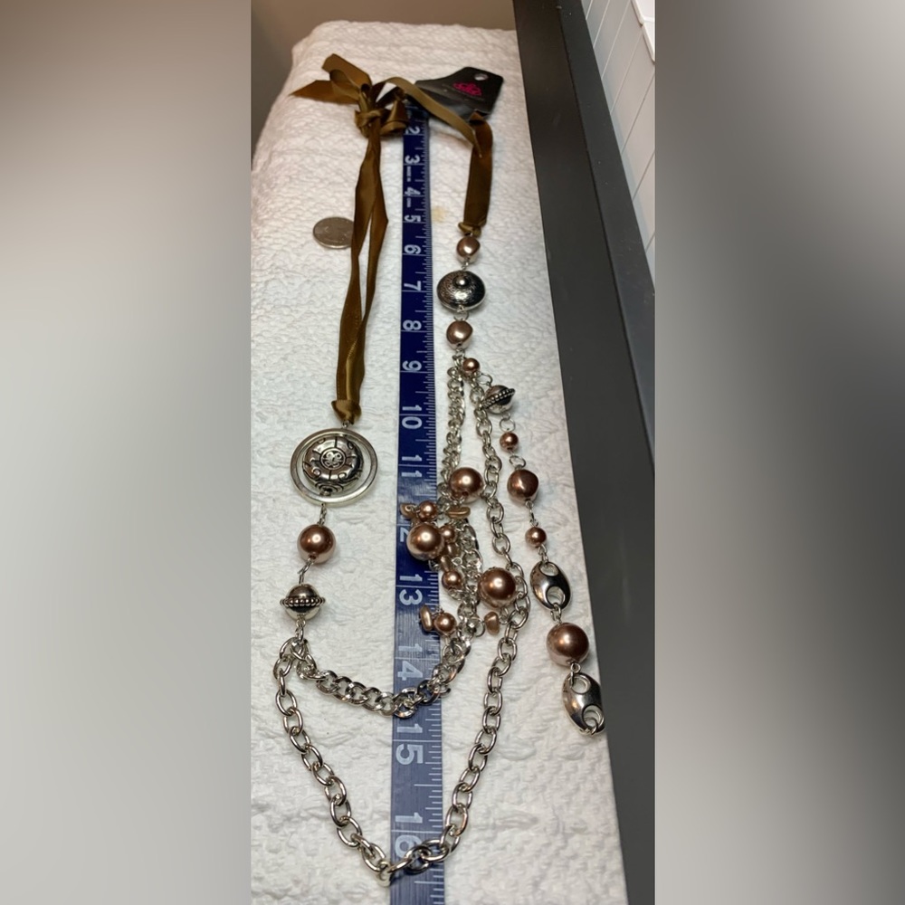 Long charm and brown ribbon costume necklace.